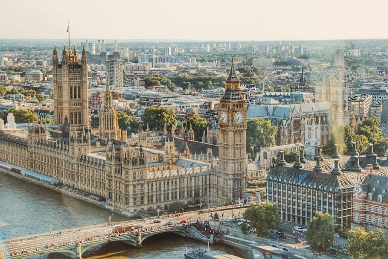 American traveler using smartphone with London Big Ben skyline in background