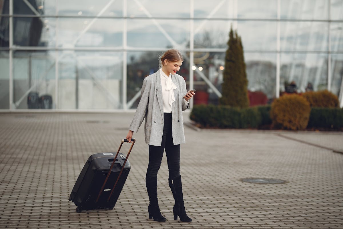 Smiling traveler using smartphone at airport with UK SIM card