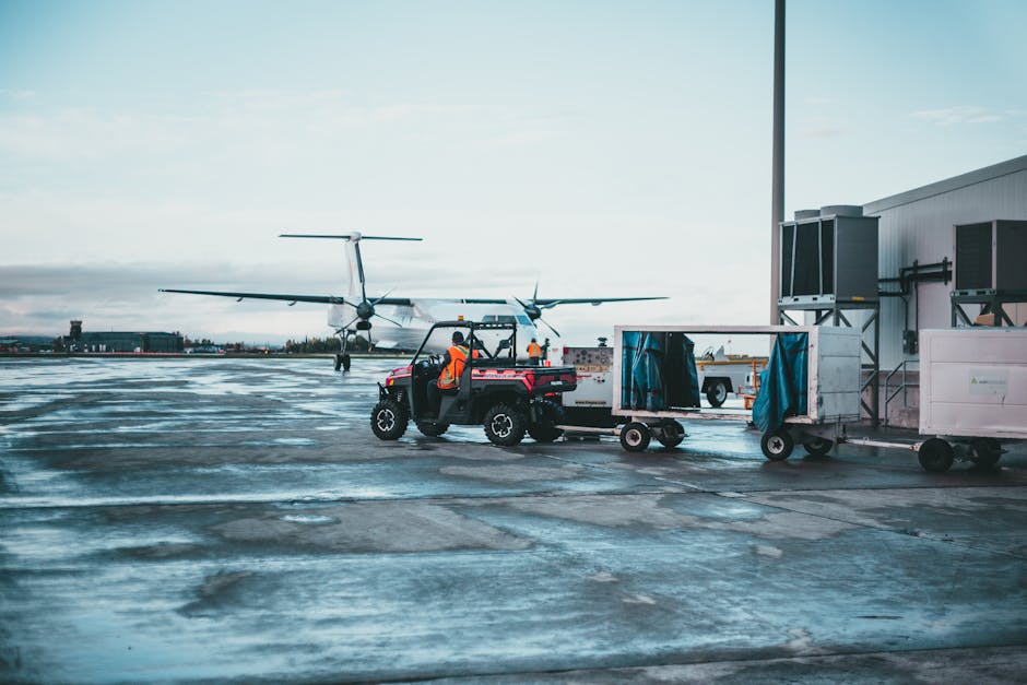 Airport crew managing luggage near airplane at dawn