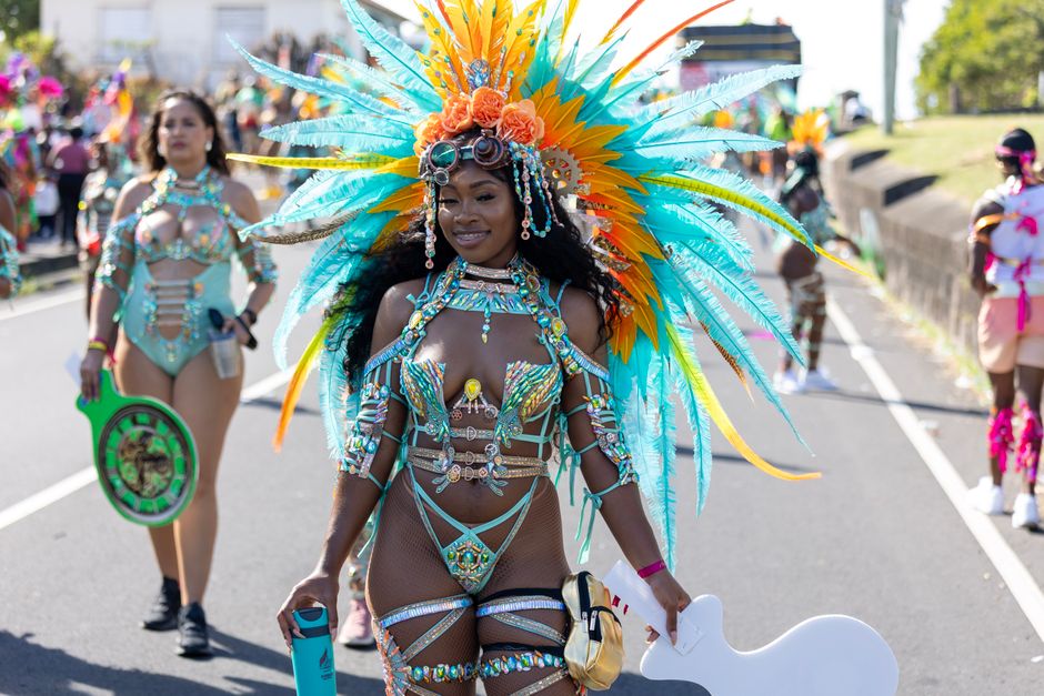 Performer in an elaborate feathered mas costume at a Caribbean street carnival in London
