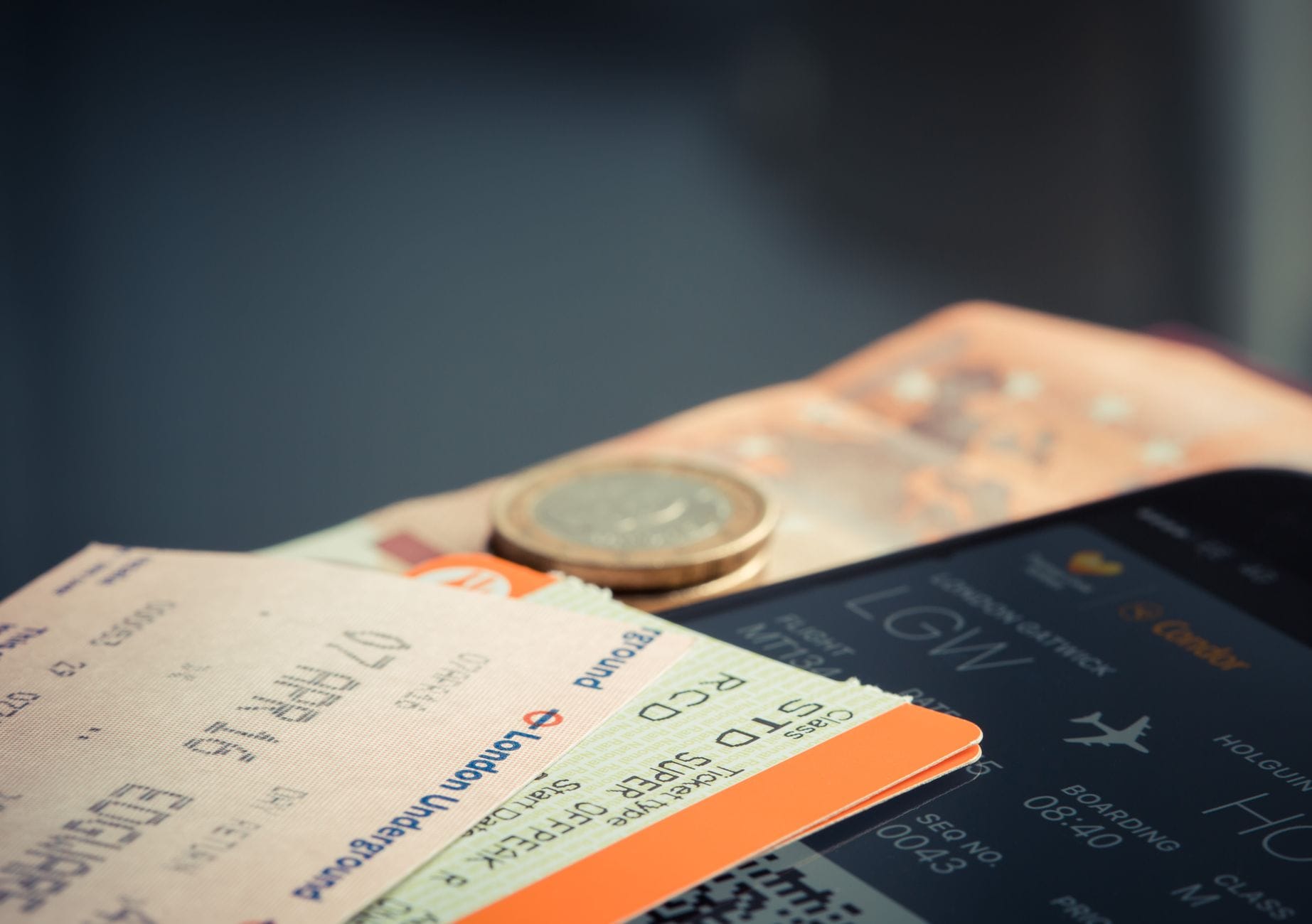 A traveler holding a phone showing a return flight boarding pass at the airport