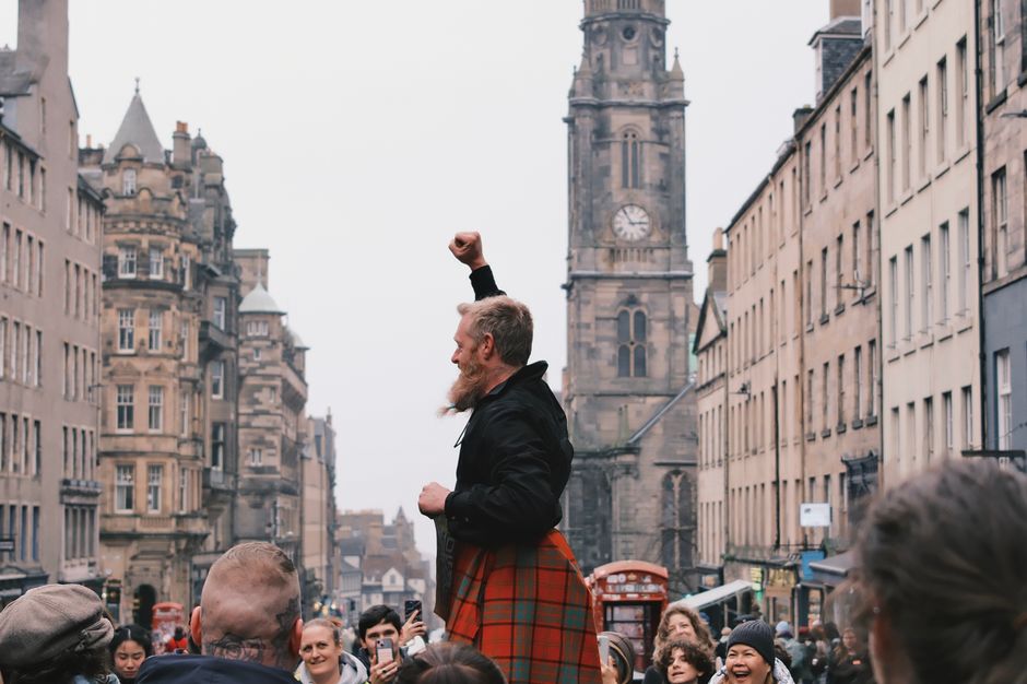 Street performers entertaining a large crowd on Edinburgh's Royal Mile during the Fringe