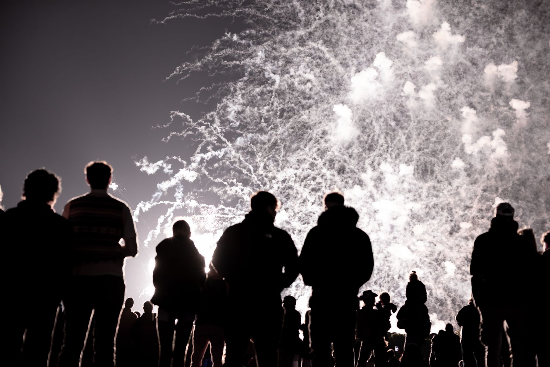 A large fireworks display lighting the night sky over a crowd on Bonfire Night in Britain