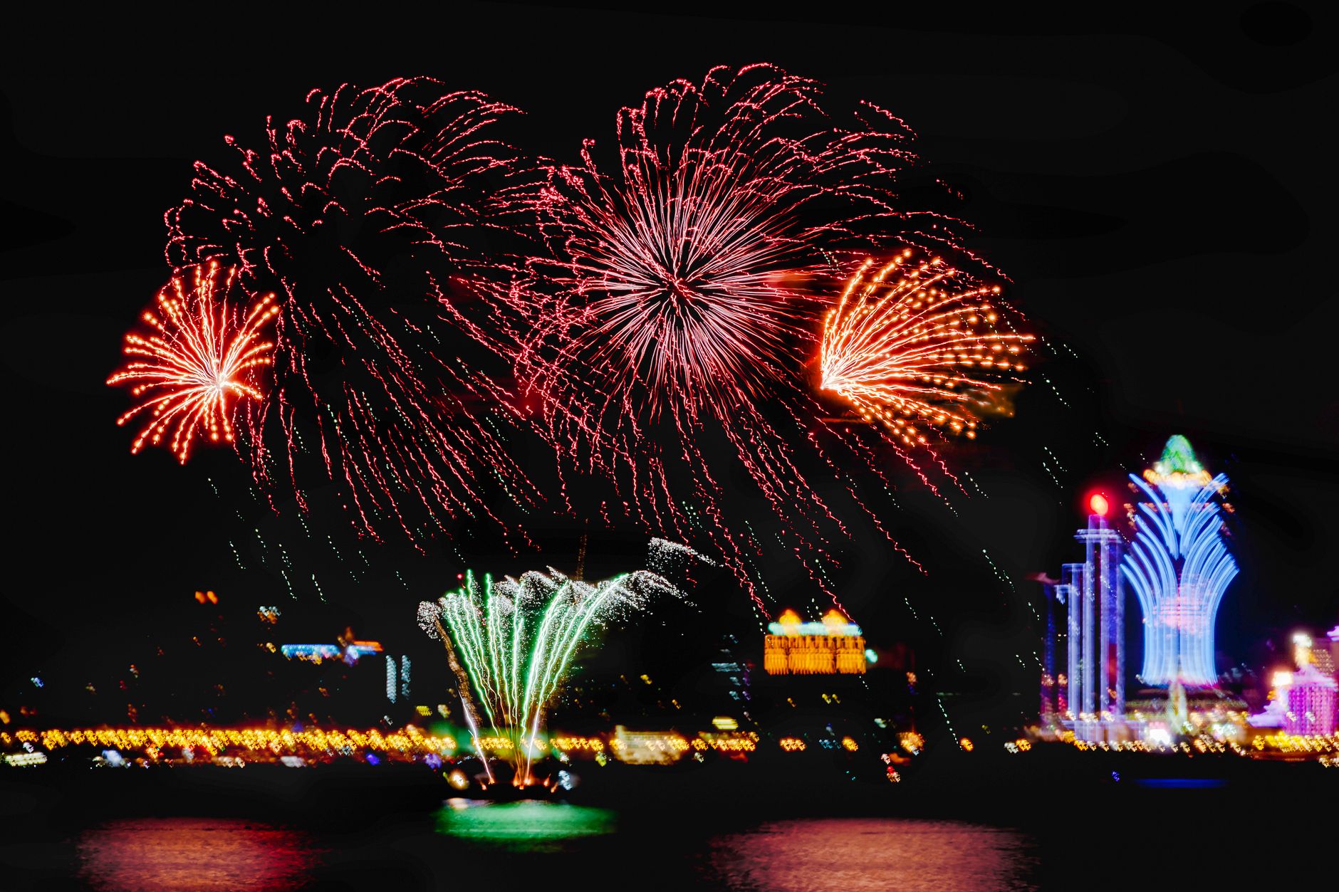 Colorful fireworks bursting over a London park with the city skyline in the background