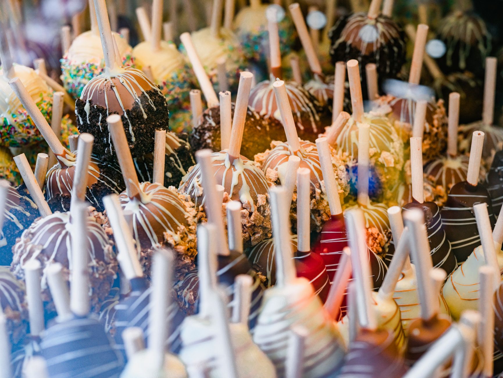 Glossy red toffee apples on a food stall at an autumn night market in Britain