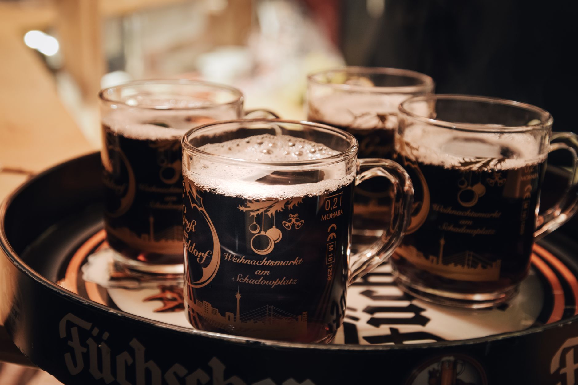 Steaming cups of mulled wine on a wooden Christmas market stall at a winter festival